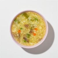 Egg Drop Soup · Wispy beaten eggs in a flavorful chicken broth with peas and carrots.