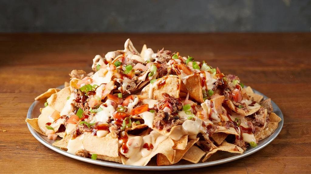 Bbq Nachos · BBQ Nachos include freshly fried tortilla chips, your choice of meat, and our signature queso.   Diced green onion, diced tomato, jalapeños and sour cream are included on the side.