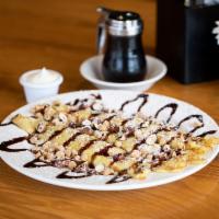 Buckeye Crepes · Three delicate crepes filled with Nutella®, topped with toasted hazelnuts, Reese’s® peanut b...