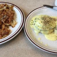 Eggs Benedict · Two poached eggs and ham on an English muffin, topped with hollandaise sauce, served with ha...