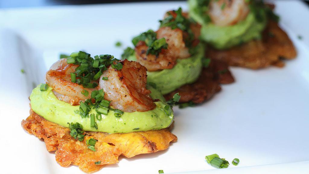 Shrimp Tostones · Three green fried plantains topped with guasacaca and sauteed shrimps. Vegetarian.