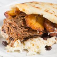 Pabellon Arepa · Shredded beef, black beans, sweet plantains, and Caribbean cheese. Traditional Venezuelan gl...