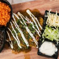 Enchiladas · Three enchiladas topped with sour cream with sides of beans and rice.