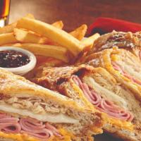World Famous Monte Cristo · Honey wheat bread layered with tender ham, roasted turkey, Swiss and American cheeses. Batte...