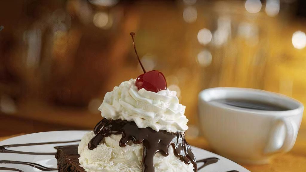 Brownie Bottom Pie · A Bennigan's classic! A chewy chocolate fudge brownie with vanilla ice cream on top, covered with hot fudge, whipped cream and a cherry.