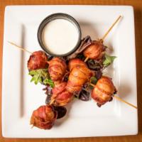 Bacon-Wrapped Cheese Curds · A skewer of eight cheese curds wrapped in crispy bacon.