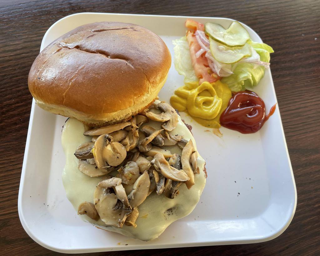 Provolone Mushroom Burger · 1/3 pound grilled burger with provolone cheese, mushrooms, ketchup, mustard, tomatoes, onions, lettuce, and pickles, served on a toasted brioche bun.