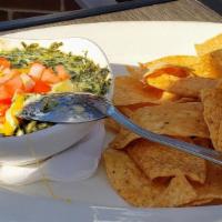 Spinach Artichoke Dip · A rich and creamy blend of artichoke hearts, spinach, and baked cheeses topped with diced to...