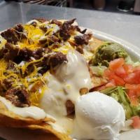  Steak Fajita Nachos · Tortilla chips topped with white queso, beans, mixed cheeses, lettuce, tomatoes, sour cream ...