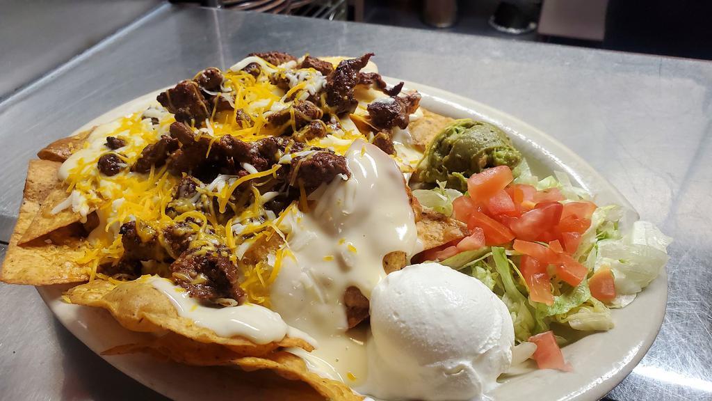  Steak Fajita Nachos · Tortilla chips topped with white queso, beans, mixed cheeses, lettuce, tomatoes, sour cream , guacamole and grilled steak.