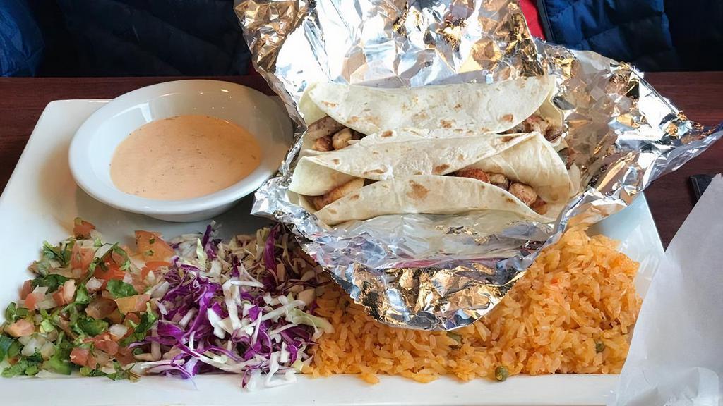Fish Tacos · Three tacos, your choice of corn or flour tortilla, served with a side of shredded cabbage, our special sauce and rice.