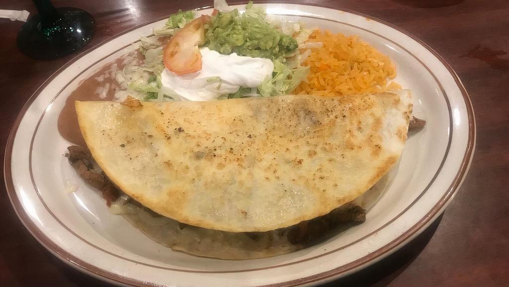 Fajita Quesadilla · A floor tortilla filled with your choice of steak, chicken or combination with sautéed bell peppers, onions and tomatoes, then lightly grilled, served with Mexican rice, refried beans and salad.