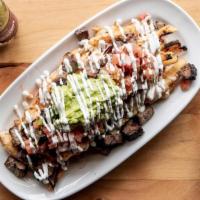 Carne Asada Fries · Wood-fire grilled flank steak, chile crusted potato fries, and Chihuahua cheese; topped with...