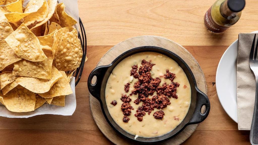 Queso Con Chorizo · Cheese dip spiked with Mexican cerveza, chile serrano, and house made chorizo sausage. Comes with Chips