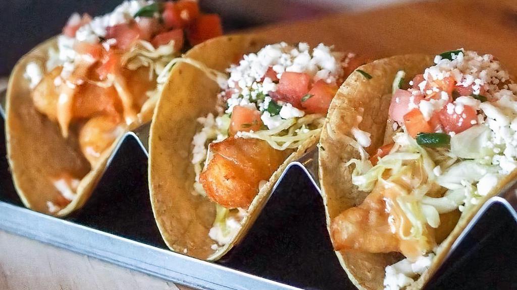 Fried Baja Fish · Beer battered tilapia – chipotle baja sauce, shredded cabbage, pico de gallo, and queso fresco, on a corn tortilla