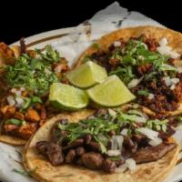 Taco De Asada · Tacos are made with larger tortillas, served with cilantro and onion.
