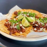 Taco Adobada · Tacos are made with larger tortillas, served with cilantro and onion.