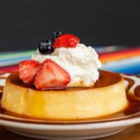 Flan · macerated berries and whipped cream.