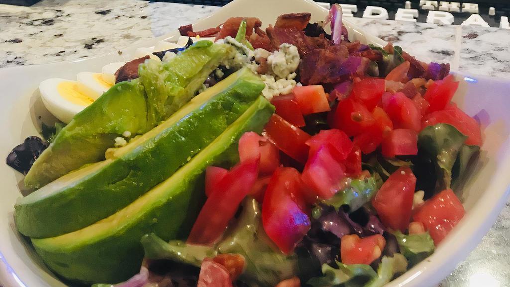 Munchies Blue Cheese Cobb Salad · Mixed greens tossed in red wine vinaigrette dressing and topped with hard-boiled eggs, thick-cut applewood smoked bacon, tomatoes, blue cheese crumbles and avocado