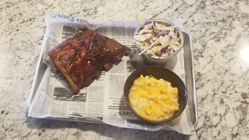 Half Slab Of Ribs · Half Slab (4 bones) Fall-off-the-bone ribs, dressed in our own BBQ Honey or Carolina Tangy Gold. Your choice of side: Mac and Cheese, Mashed Potato, Coleslaw, Tortilla Chips, Salad or Fries