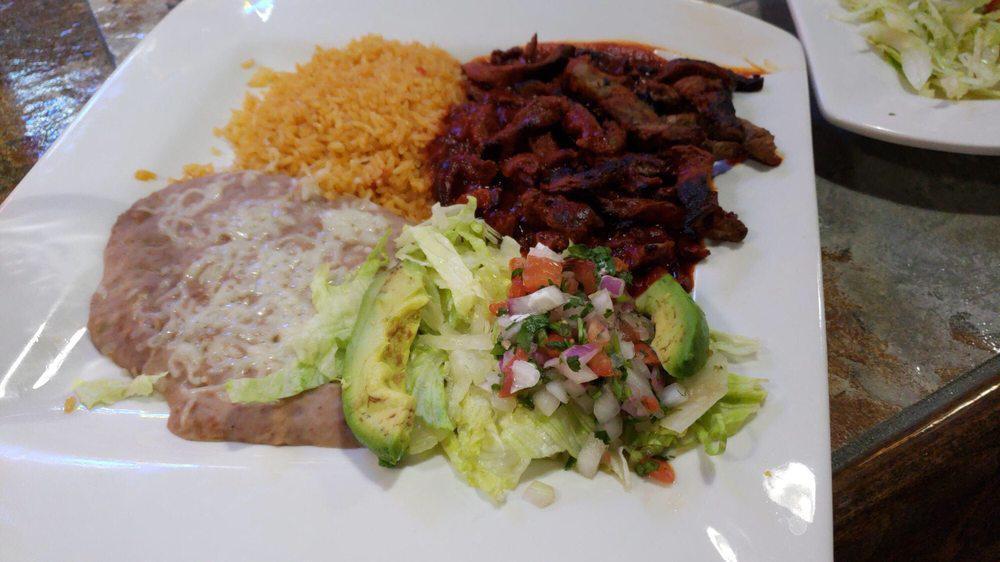 Chile Colorado · Tender sliced skirt steak simmered in Colorado sauce and served with rice, beans, lettuce, pico de gallo, avocado and warm tortillas.