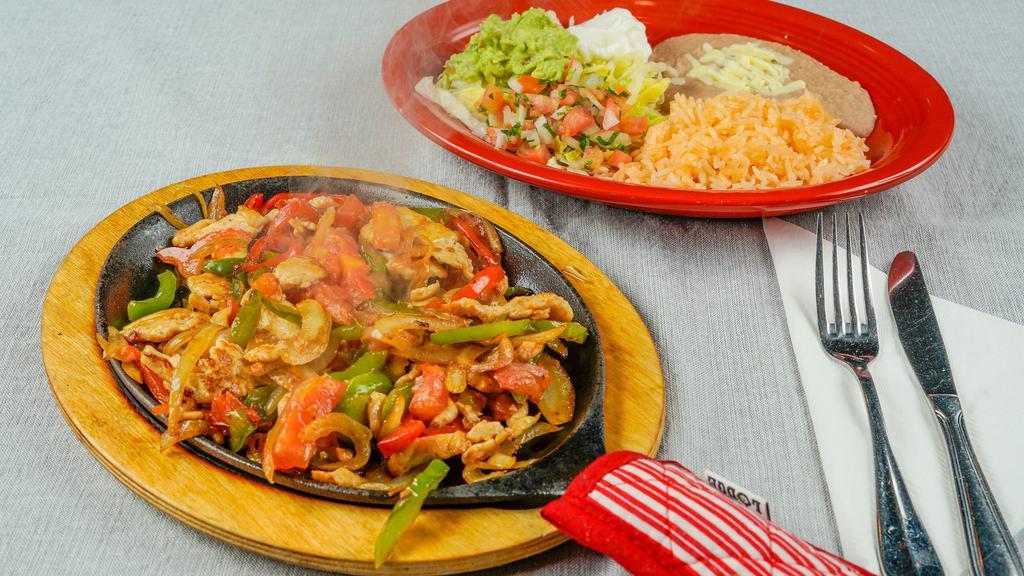 Fajitas · Grilled chicken, sautéed bell peppers, onions, and tomatoes. Served on a hot skillet. Served with rice and beans. Lettuce sour cream, pico de gallo, and guacamole on the side. Choose from corn or flour tortillas.