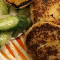 Crab Cakes · with charred lemon aioli and a cucumber-onion salad drizzled with chili oil.