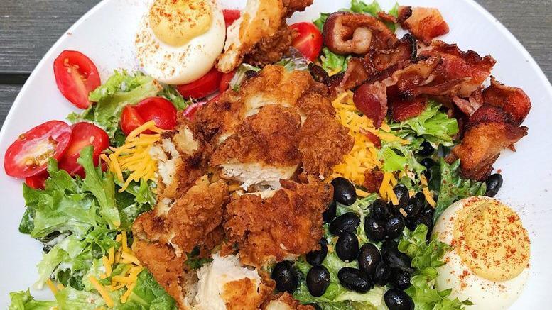 Southwestern Cobb Salad · Mixed greens, bacon, black beans, avocado, tomato, deviled eggs, cheddar cheese, and pimento ranch dressing.