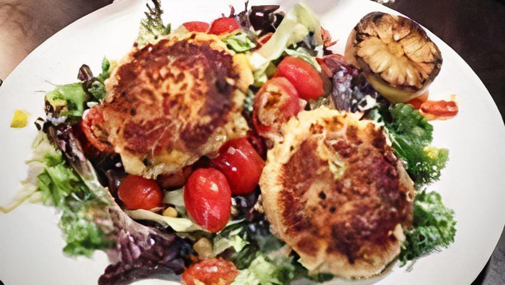 Crab Cake Salad · Two pan-seared crab cakes, mixed greens, zucchini, squash, bell pepper, onion, lima beans, corn, tomatoes, and charred lemon buttermilk dressing.