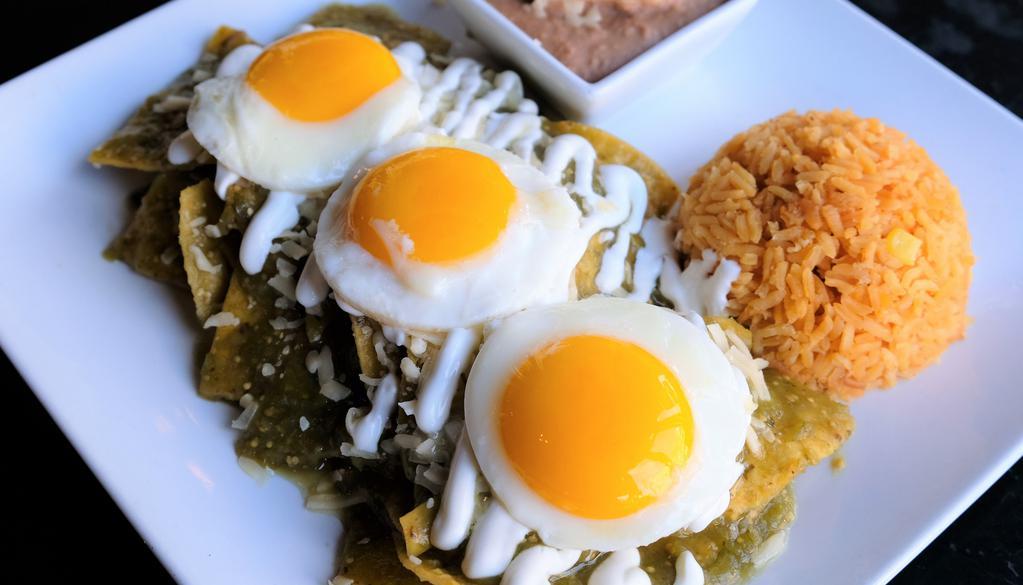 Chilaquiles Verdes · A traditional Mexican breakfast dish. Crispy tortillas simmed with salsa verde and onions. Topped with 3 egs (Your way) and finished with sour cream and queso Chihuahua.  Served with Mexican rice and refried beans.