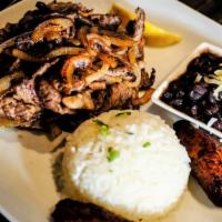 Bistec Encebollado · Marinated steak sauteed with grilled onions. Served with sweet plantains, white rice and bla...