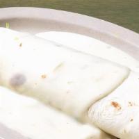 Queso Burrito · Your choice of burrito covered in our spicy white queso  sauce