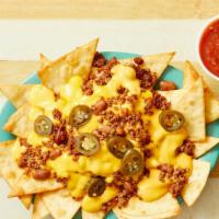 Nacho Supreme · Flour tortilla chips topped with refried beans, taco meat, your choice of nacho cheese or qu...