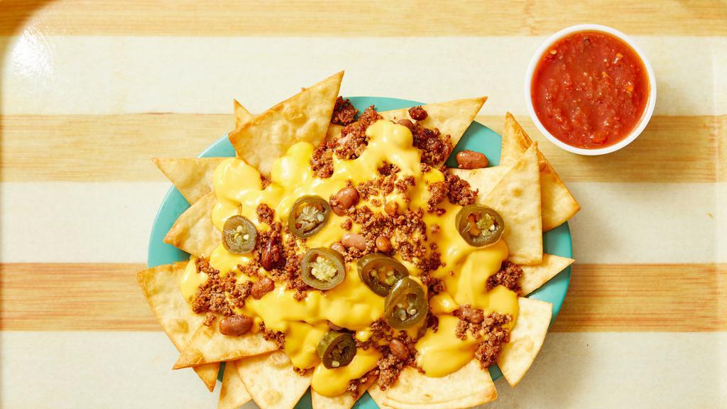 Nacho Supreme · Flour tortilla chips topped with refried beans, taco meat, your choice of nacho cheese or queso blanco.  Add sliced jalapeno peppers for a kick!