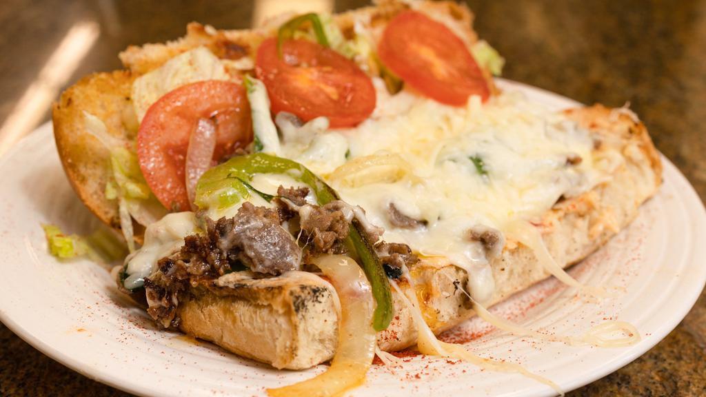 Philly Cheesesteak · The famous sandwich is made with tender slices of steak, caramelized onions, green pepper, and melted pepper jack cheese hugged by a toasted butter bun.