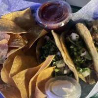 3 Steak Tacos · Three steak tacos topped with cilantro and onion  with a side of nacho chips, salsa, and sou...