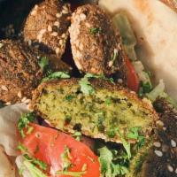 Falafel · A large roll of pita bread filled with falafel mixed with tahini sauce, tomatoes, onions and...