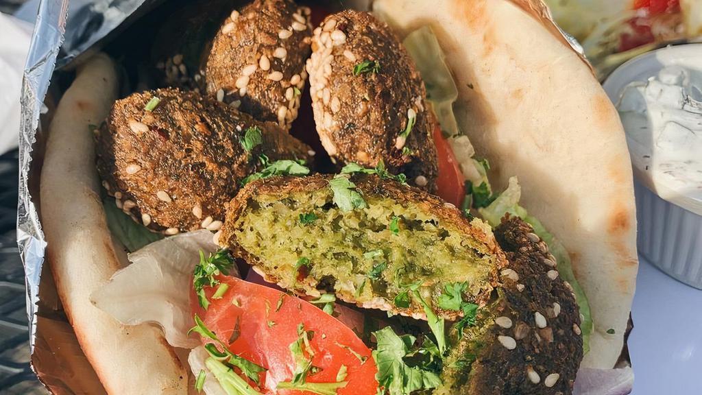 Falafel · A large roll of pita bread filled with falafel mixed with tahini sauce, tomatoes, onions and lettuce.