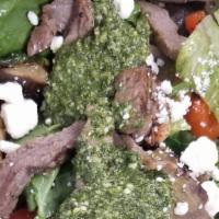 Grilled Steak Salad · Fire grilled steak, romaine, basil pesto, spinach and arugula, feta, green onions,  crunchy ...