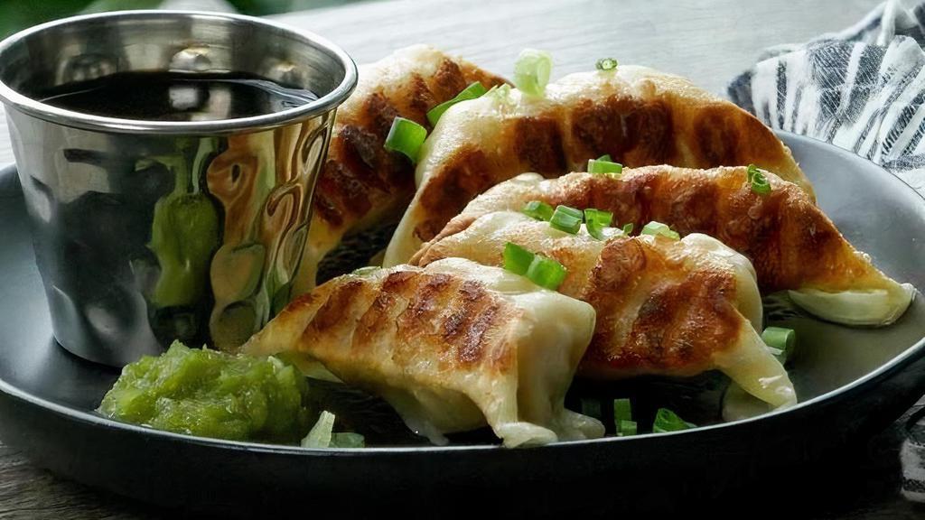 Chicken Gyoza · Pan-fried chicken and vegetable dumplings served with yuzu kosho and a soy dipping sauce.