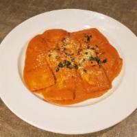 Ravioli Di Pollo · Homemade pasta filled with chicken and ricotta in a pink tomato sauce topped with parmigiano...