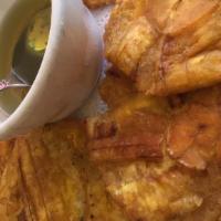 Tostones · Green plantain with garlic sauce