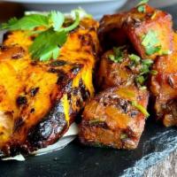 Salmon Tikka · Grilled salmon fillet suffused with pleasant herbs and spices served with cumin tempered pot...