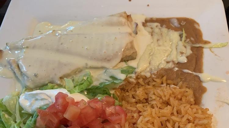 Lunch Chimichanga · One chimichanga stuffed with choice of chicken or beef and topped with cheese dip. Served with lettuce, tomatoes, cheese, sour cream, rice, and beans.