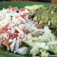 Guacamole Salad · This deliciosa Mexican salad is served with lettuce, tomatoes, guacamole, and shredded cheese.