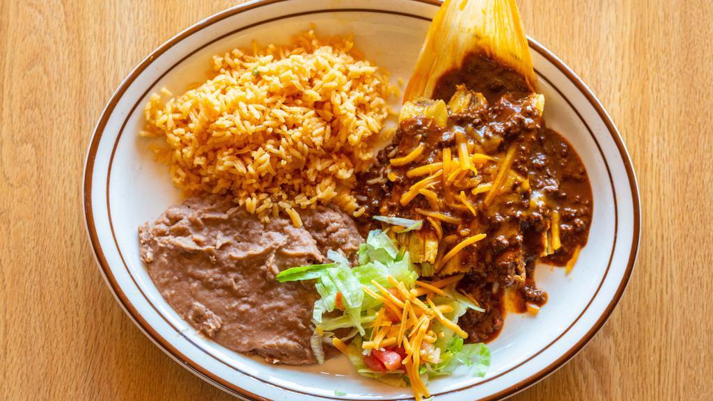 Tamale Dinner · Three pork tamales topped with our chili con carne and shredded Cheddar cheese. Served with rice, beans, and a small garnish salad.