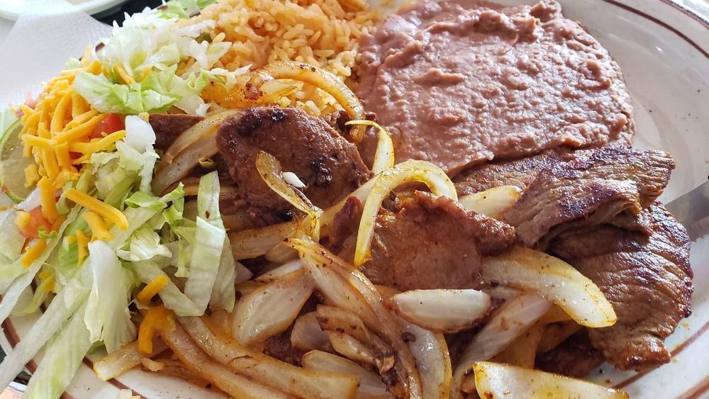 Carne Asada Dinner · Steak meat cooked on the grill with onions. Served with small garnish salad, rice beans, and three flour tortillas.