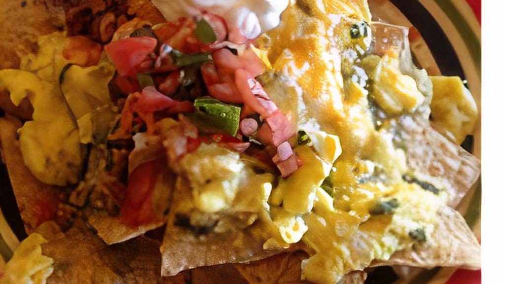 Chilaquiles · Served on tortilla chips, cheese, green salsa, rice, refried beans, sour cream and pico de gallo