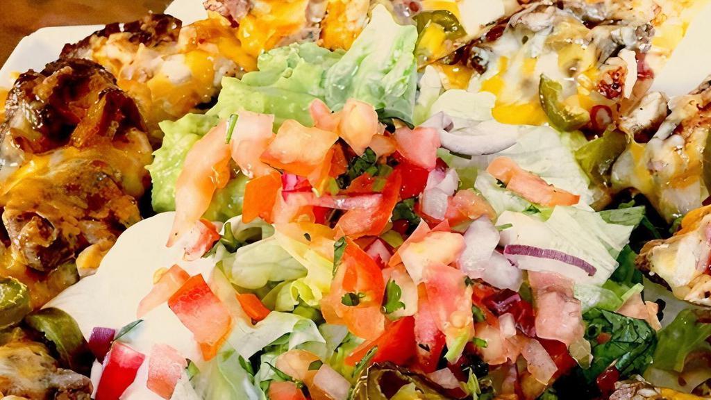 Cheezy Nacho Beef Platter · Tortilla chips smothered with shredded beef and nacho cheese, guacamole, pico de gallo, and sour cream