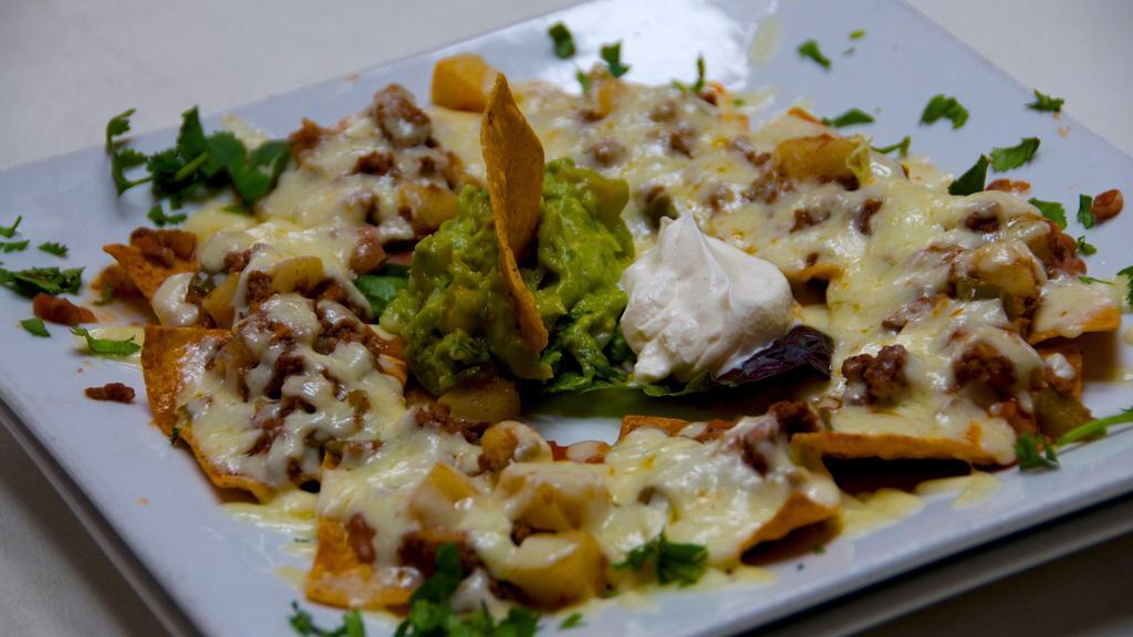 Nachos · Tortilla chips, beans & chihuahua cheese. Served with guacamole & sour cream.